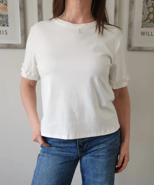 Polera blanca con vuelitos en las mangas